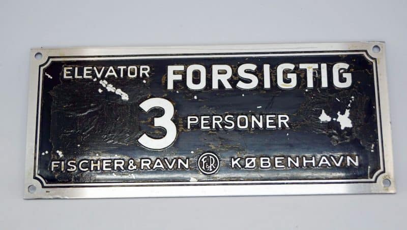 Elevatorskilt. 3 Personer. Forsigtig. Fischer & Ravn København