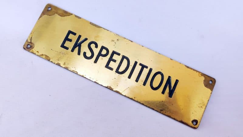 Messing skilt med nedfræset tekst: Ekspedition