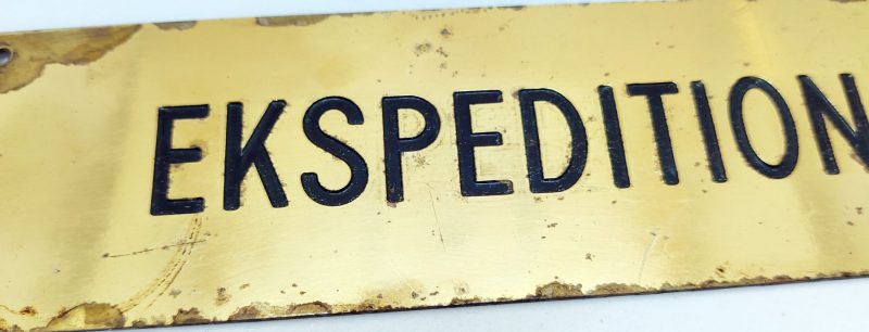 Messing skilt med nedfræset tekst: Ekspedition