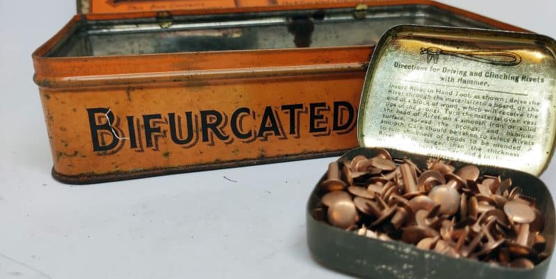 Bifurcated Rivets (Kobber nitter). Engelsk salgsstander i form af stor blikdåse med 2 mindre dåser