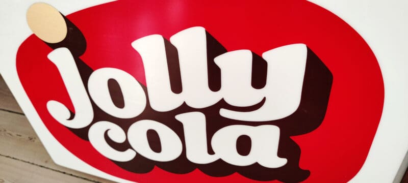 Jolly Cola lysskilt i plast. I træramme