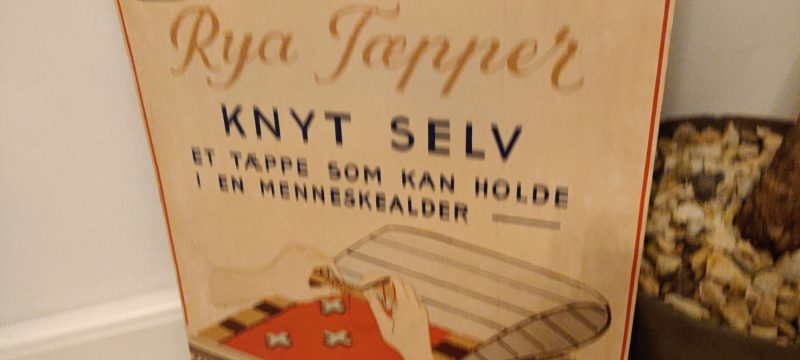 Papskilt. Reklame for Sesam Rya Tæpper - Knyt selv - et tæppe som kan holde i en menneskealder. Det kan lære det paa et Øjeblik