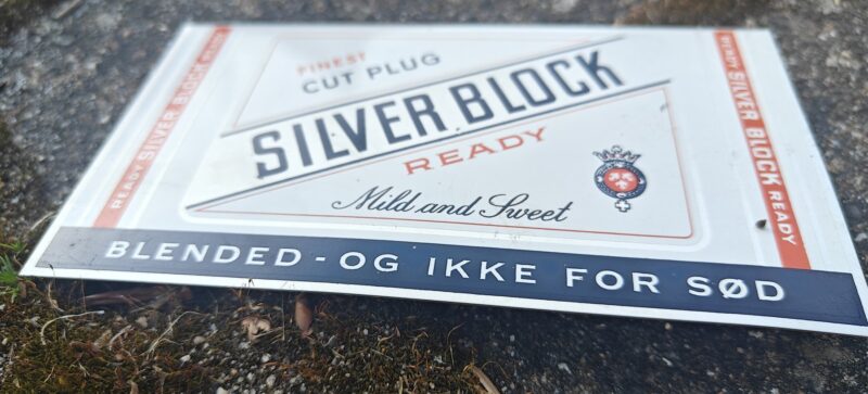 Blikskilt fra W.Ø. Larsen. Silver block. Hyldeforkant