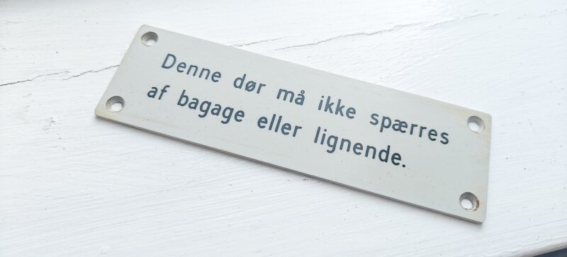 Denne dør må ikke spærres af bagage eller lignende. Sporvognsskilt