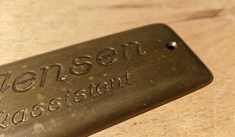 K. Jensen. Bankassistent. Navneskilt i messing