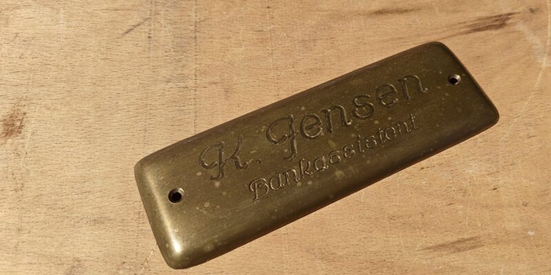 K. Jensen. Bankassistent. Navneskilt i messing