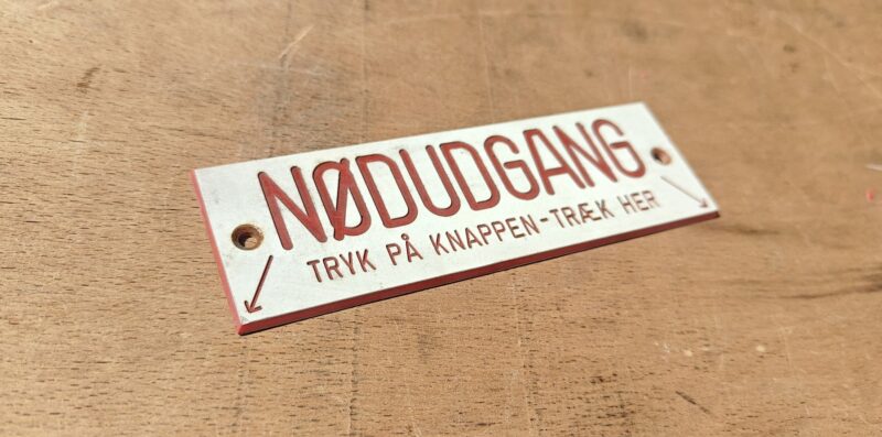 Sporvognsskilt. Nødudgang. Tryk på knappen. Træk her