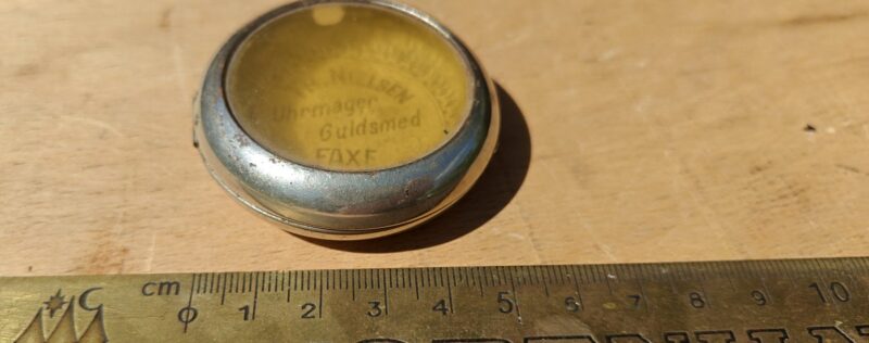 Th. Nielsen. Uhrmager og guldsmed Faxe.  Telf. 53. Blikdåse itui til lommeur med reklame