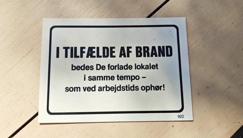 Humørskilt (plastik). I TILFÆLDE AF BRAND bedes de forlade lokalet i samme tempo - som ved arbejdstids ophør!